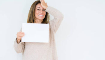 Middle age woman holding blank paper sheet