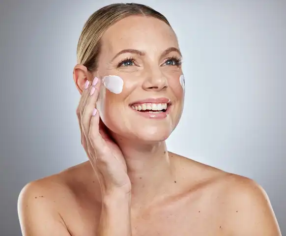 A woman applying a DIY cream to her face as part of her skincare routine, showcasing a Homemade Skin Treatment.